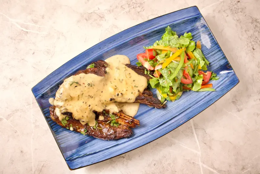 T-Bone Steak with creamy sauce and fresh salad